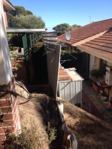 1 metre reconstituted limestone block retaing wall contractor and colorbond fence core drilled on top